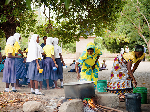 Mother Support Group members in Tanzania prepare uji for school children