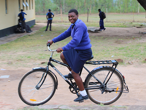 Aneni riding her bicycle to school