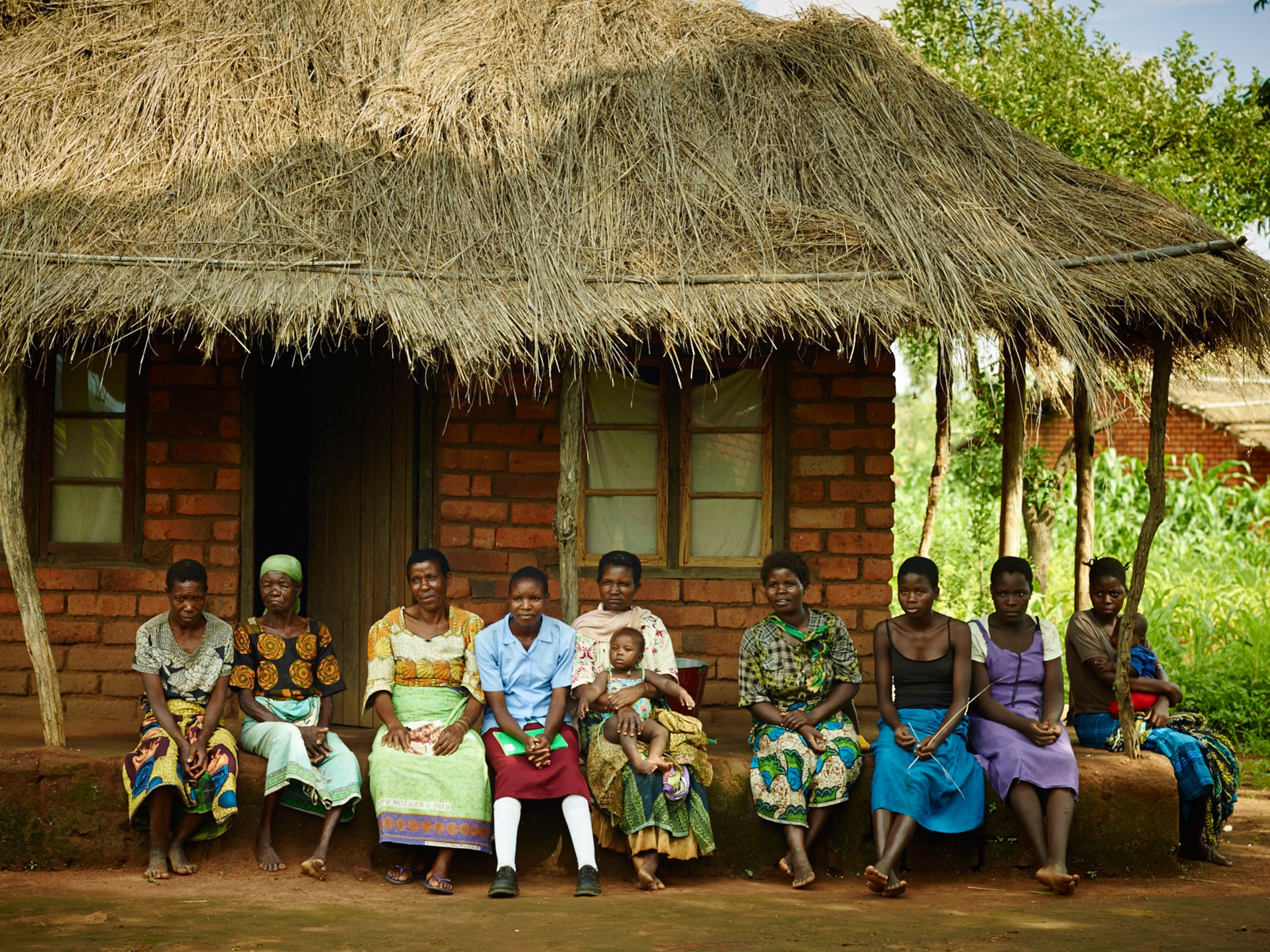 Chikondi sitting with members of her community