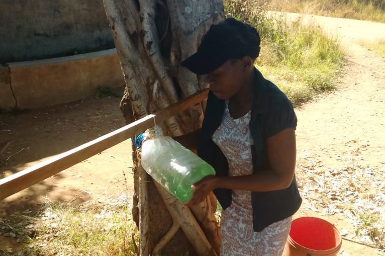 Juliet installs soap at borehole in Zimbabwe