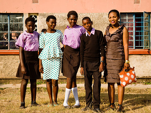 CAMA Member Mwamba with four children she supports at school. CAMA Member Mwamba with four children she supports at school.